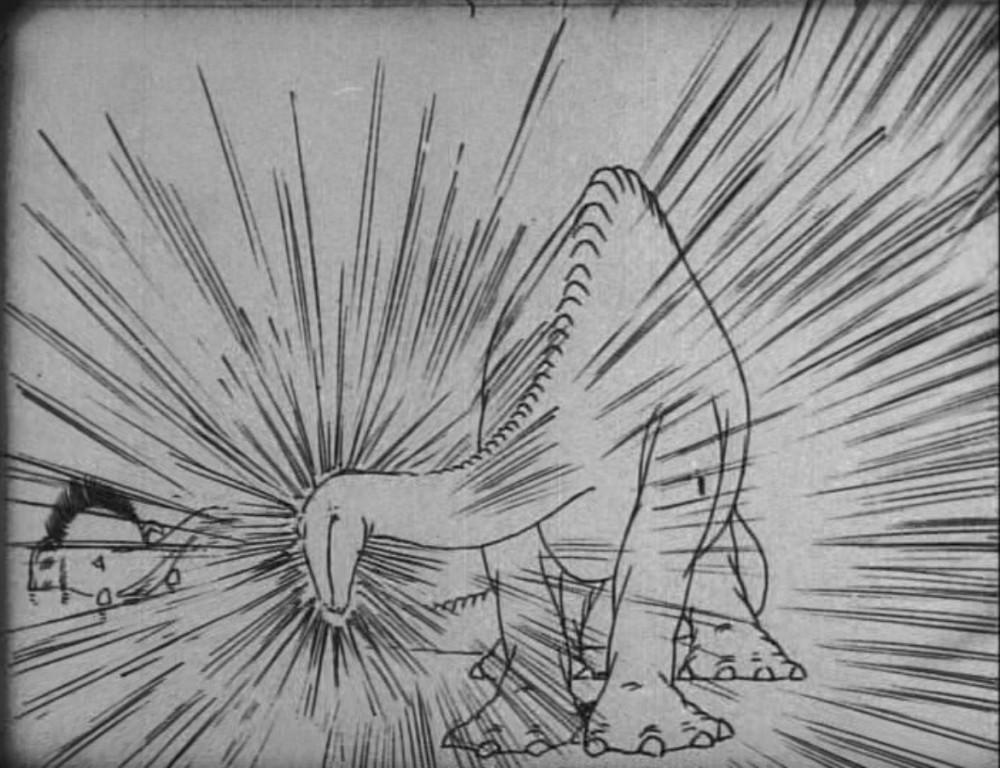 Standbild aus einem Zeichentrickfilm: Ein gezeichneter Saurier hat den Kopf nach links gewendet, von wo aus ihn ein Mammut aus einem See heraus mit seinem Rüssel mit Wasser bespritzt. Der Wasserstrahl prallt in einem sternförmigen Linienkranz am Kopf des Sauriers ab.